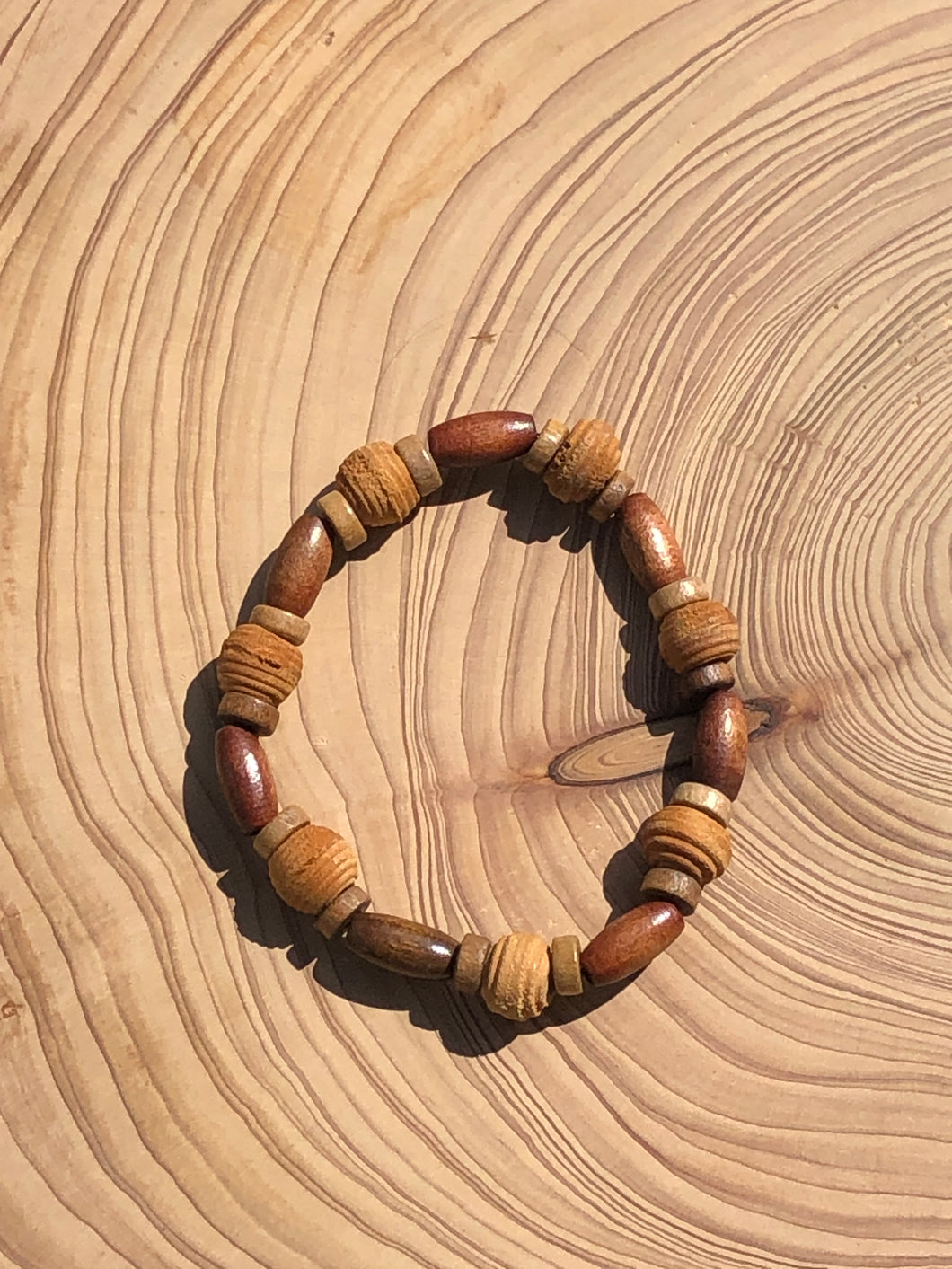 Handmade beaded bracelet on elastic. Made out of brown and beige textured recycled beads.