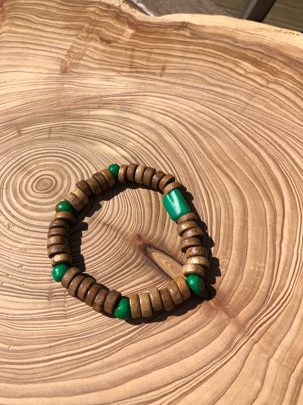 Handmade beaded bracelet on elastic. Made out of emerald green and brown recycled beads.