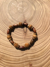 Load image into Gallery viewer, Handmade beaded bracelet on elastic. Made out of brown and beige textured recycled beads.
