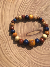 Load image into Gallery viewer, handmade beaded bracelet on elastic. Made out blue, brown and beige recycled beads.
