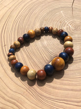 Load image into Gallery viewer, handmade beaded bracelet on elastic. Made out blue, brown and beige recycled beads.
