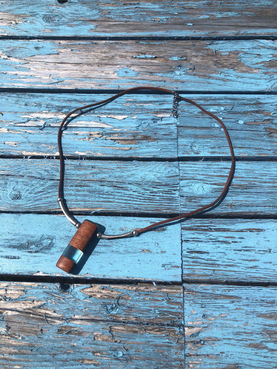 Pendant necklace handmade out of reclaimed hard wood and resin. On adjustable suede cord.